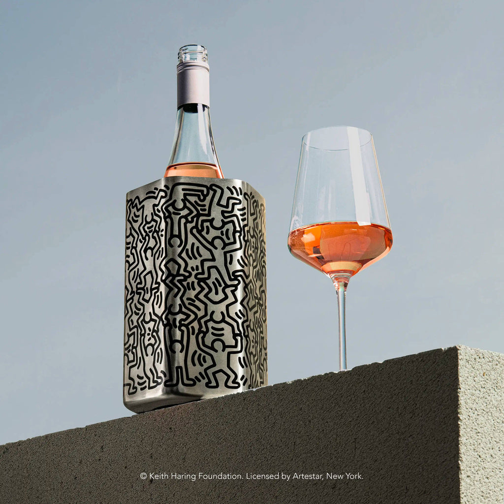 Vacu Vin Keith Haring wine cooler on a table with a glass of wine