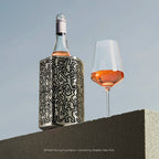 Vacu Vin Keith Haring wine cooler on a table with a glass of wine