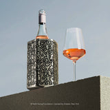 Vacu Vin Keith Haring wine cooler on a table with a glass of wine
