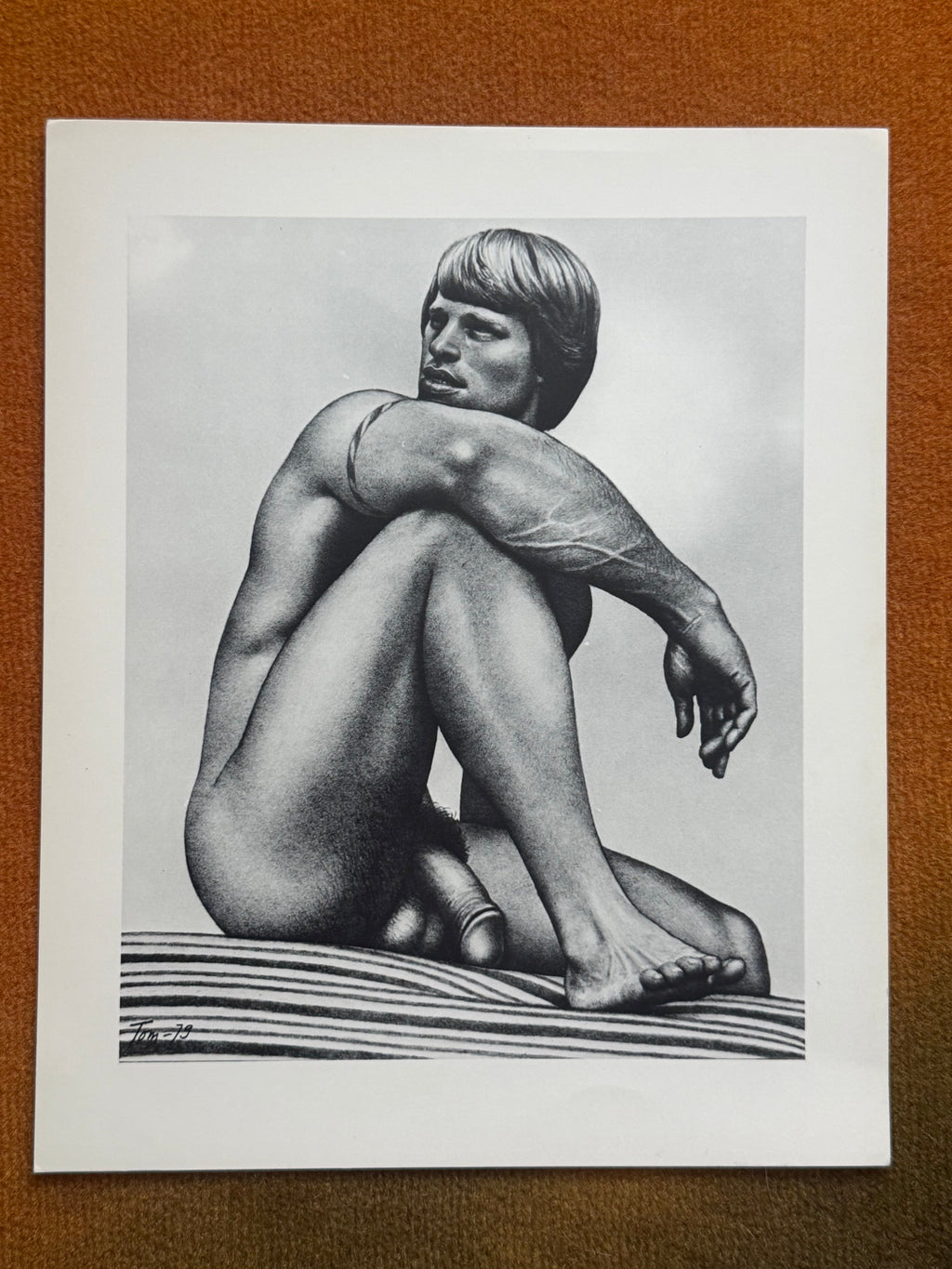 Tom of Finland, seated nude on a striped mat, print dated Tom-79