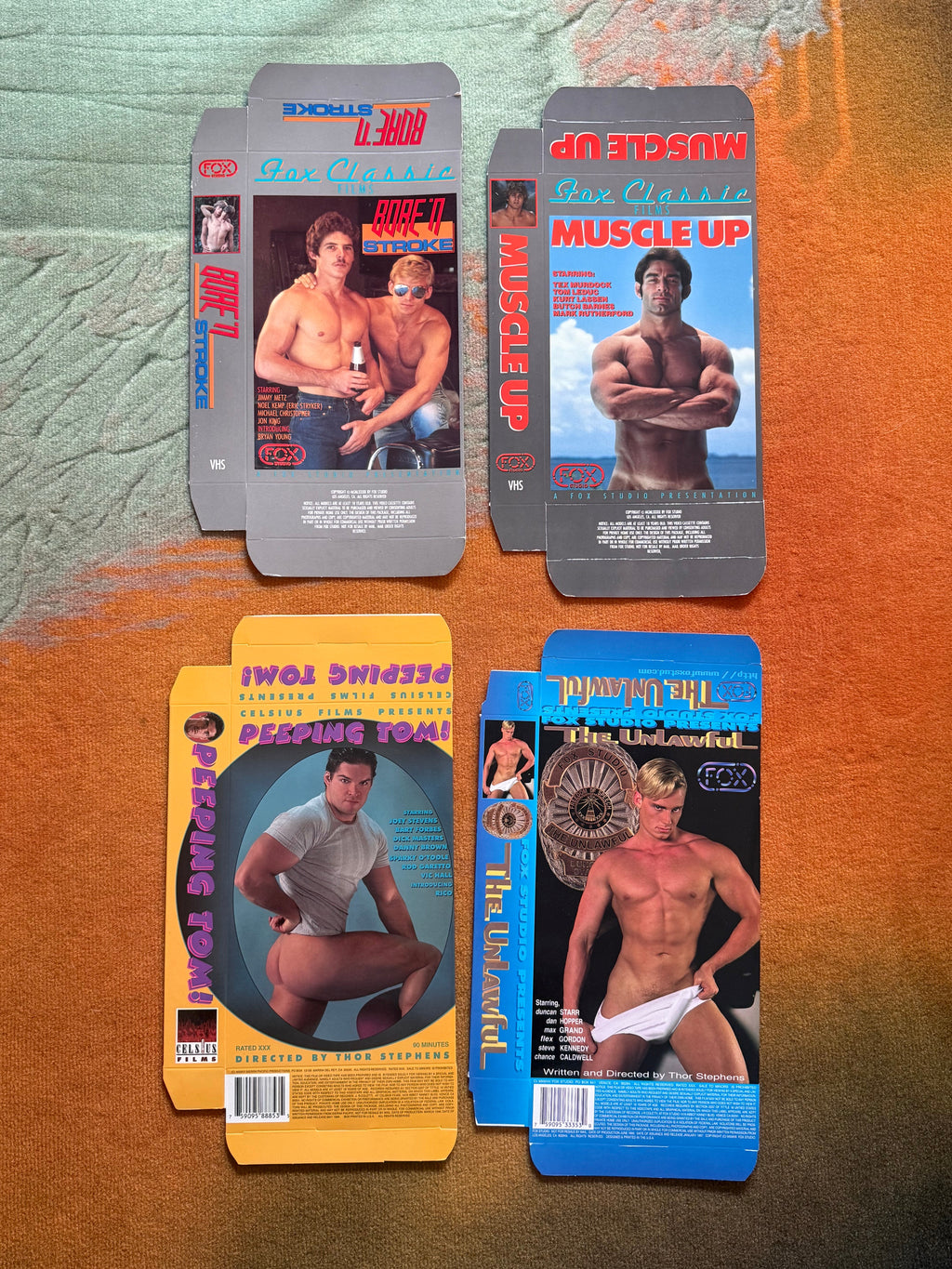 Four flattened vintage VHS sleeves including Muscle Up and Peeping Tom!